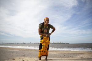 La Santa on the beach in a yellow skirt, laughing